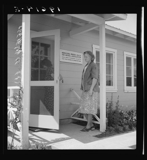 Tulare County, Farmersville, California. Farm Security Administration (FSA) camp for migratory agricultural workers. Entering clinic of Agricultural Workers' Health and Medical Association (FSA) for nurse's help with sick baby. Older woman says, "I'm just a neighbor and feel real sorry for them"
