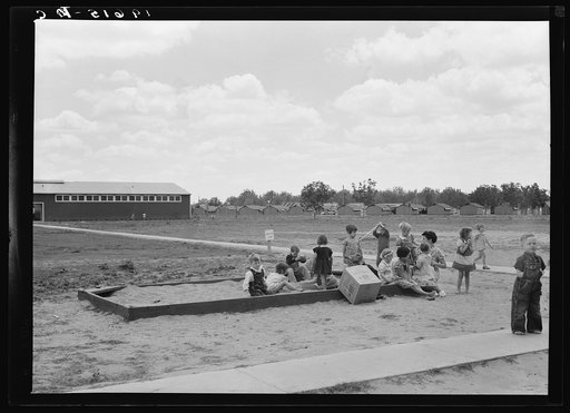 Tulare County, California. Farm Security Administration (FSA) camp for migratory agricultural workers. Nursery school children with their teacher, who is assigned to the camp by Works Progress Administration (WPA). Steel shelters in background