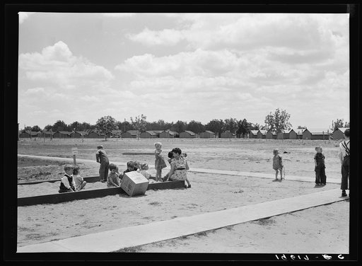 Untitled photo, possibly related to: Tulare County, California. Farm Security Administration (FSA) camp for migratory agricultural workers. Nursery school children with their teacher, who is assigned to the camp by Works Progress Administration (WPA). Steel shelters in background