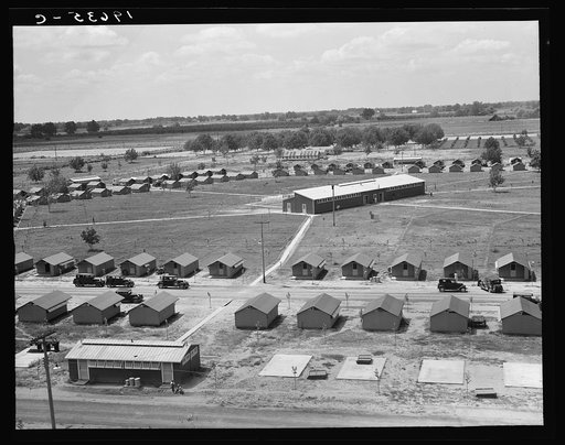 Tulare County. View of Farm Security Administration (FSA) camp for migratory laborers. Farmersville. Seen from water tower, showing pre-fabricated steel shelters for agriculture workers. The building at lower left holds toilet unit. Large building in center is camp laundry. This camp is situated in 