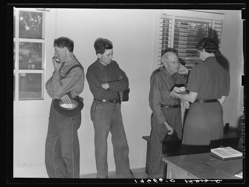 Tulare County, California. Camp for migratory agricultural workers at Farmersville. Sons, migratory workers, bring father, who is sick and old to the camp clinic