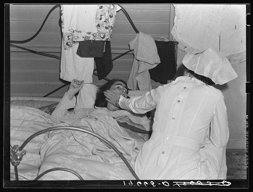 Tulare County, California. Farm Security Administration (FSA) camp for migratory agricultural workers at Farmersville. Nurse of Agricultural Workers' Health and Medical Association attends sick migrant woman while awaiting doctor