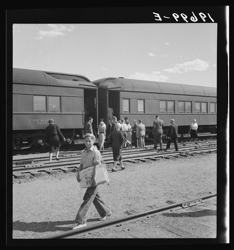 Untitled photo, possibly related to: Railroad yards, Kearney, Nebraska. Overland train passengers go back to their cars after ten minute train stop on trip between San Francisco and Chicago