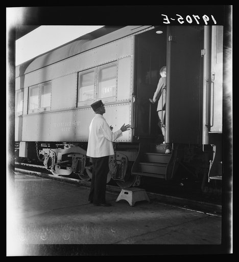 Untitled photo, possibly related to: Railroad yards, Kearney, Nebraska. Overland train passengers go back to their cars after ten minute train stop on trip between San Francisco and Chicago