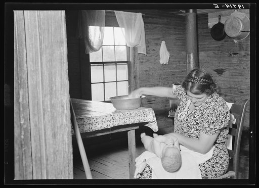 Wife of tobacco sharecropper bathing her baby in kitchen. Person County, North Carolina