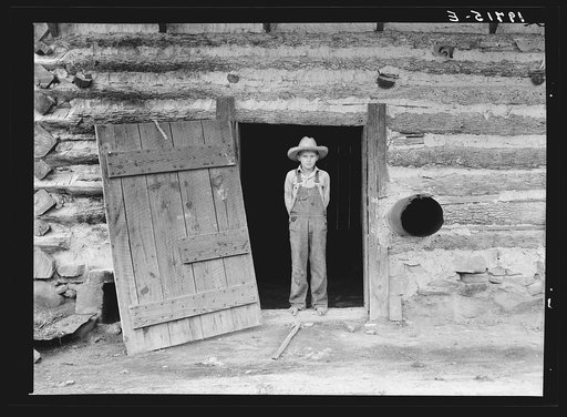 North Carolina farm boy in doorway of tobacco barn. Person County, North Carolina