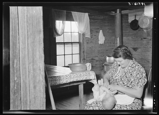 Wife of tobacco sharecropper bathing baby in kitchen. Person County, North Carolina