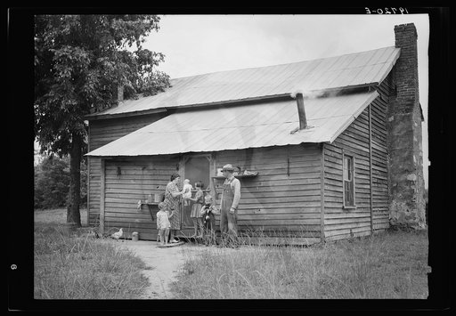 Untitled photo, possibly related to: Tobacco sharecropper and his family at the back of their house showing kitchen door, household equipment, foot path to barn. Person County, North Carolina