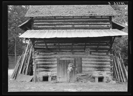 Tobacco barn. Person County, North Carolina. Piece of sheet iron on the left is used to cover the opening of the furnace when starting the fire