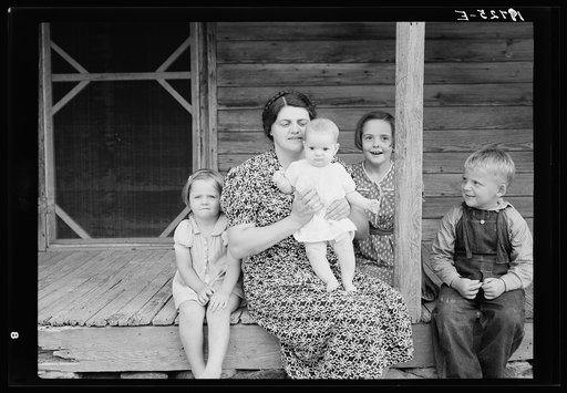 Untitled photo, possibly related to: Wife and children of tobacco sharecropper on front porch. Person County, North Carolina
