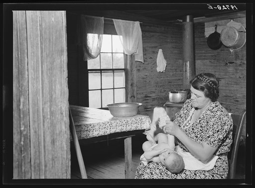 Untitled photo, possibly related to: Wife of tobacco sharecropper bathing her baby in kitchen. Person County, North Carolina