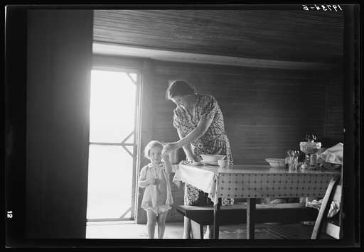 Wife and child of tobacco sharecropper. The littlest girl comes in from outside for something to eat while mother is doing her housework. The child next to the baby is called in this country the "knee baby". Person County, North Carolina