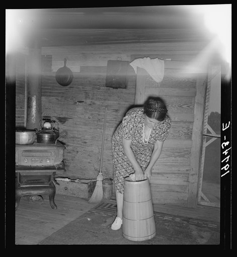 Wife of tobacco sharecropper cleaning butter churn. Person County, North Carolina