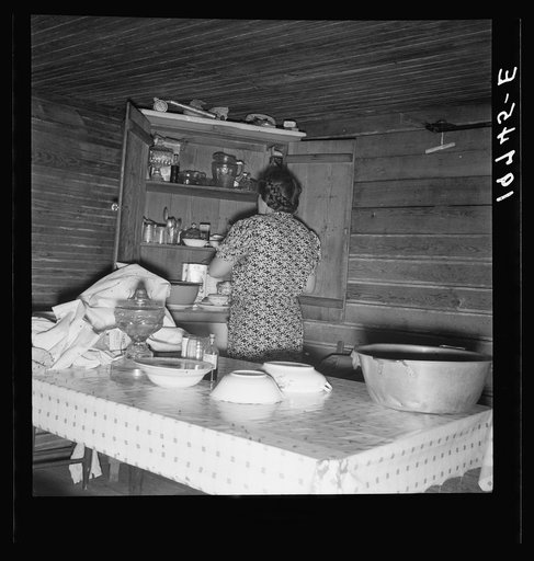 Wife of tobacco sharecropper putting breakfast dishes away. Person County, North Carolina