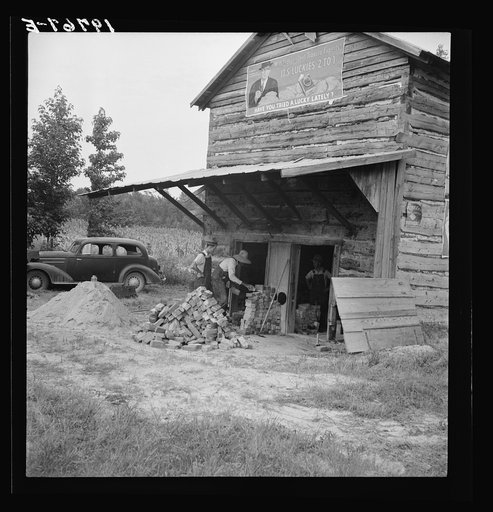 Untitled photo, possibly related to: Putting in new flues in tobacco barn. The fire burns out the bricks and furnaces have to be replaced every ten or fifteen years. Orange County, North Carolina