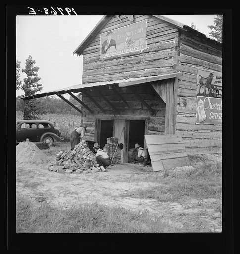 Putting in new flues in tobacco barn. The fire burns out the bricks and furnaces have to be replaced every ten or fifteen years. Orange County, North Carolina