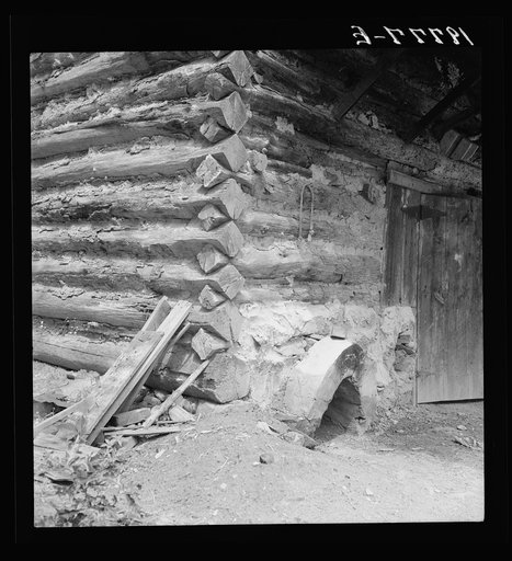 Detail of tobacco barn showing log construction and newly plastered furnace in preparation for "putting in". Person County, North Carolina
