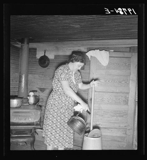 Wife of tobacco sharecropper cleaning butter churn. Person County, North Carolina