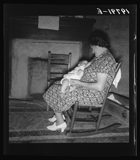 Tobacco sharecropper's wife nurses the baby after washing the dishes and before "straightening up the house." Person County, North Carolina