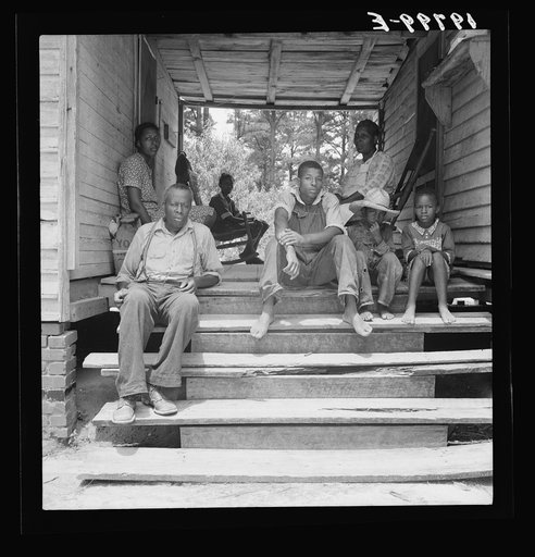 Zollie Lyon, Negro sharecropper, home from the field for dinner at noontime, with his wife and part of his family. Note dog run. Wake County, North Carolina
