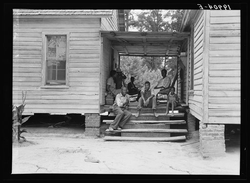Zollie Lyons, Negro sharecropper, home from the field for dinner at noontime, and part of his family. Upchurch, North Carolina. He has thirteen acres of tobacco and a labor force of five