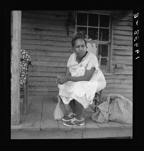 Untitled photo, possibly related to: Mother of sharecropper family and friend coming up the road in the rain, bringing home sacks of vegetables from the neighbor place. Person County, North Carolina. Off Highway 144