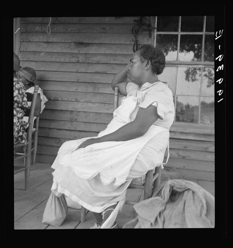 Untitled photo, possibly related to: Mother of sharecropper family and friend coming up the road in the rain, bringing home sacks of vegetables from the neighbor place. Person County, North Carolina. Off Highway 144