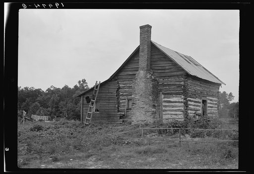 Negro sharecropper house. Note chimney leanto with kitchen stove pipe stuffed through side of wall and cap off with joint of tobacco flue to keep smoke from blowing back into house. Note also flower garden protected by slender fence of lathes. Person County, North Carolina