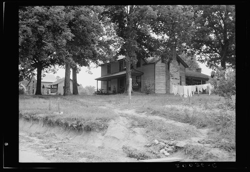 The one-and-a-half story part of this house was built fifty to sixty years ago. The two-story part was built in 1900. Farm is owned by a woman whose husband died seventeen years ago. Person County, North Carolina