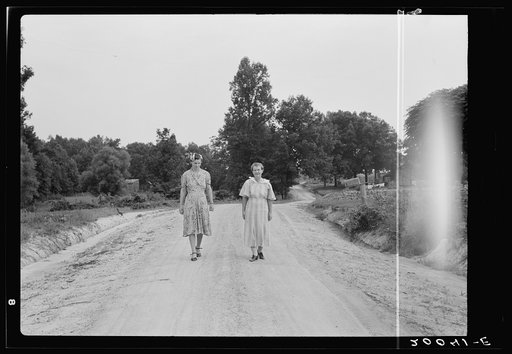 Women walking down the road to see a sick neighbor. Person County, North Carolina