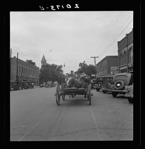 Untitled photo, possibly related to: Oxford, North Carolina. Small agricultural center. Note everpresent Confederate monument, and calf in a two horse wagon