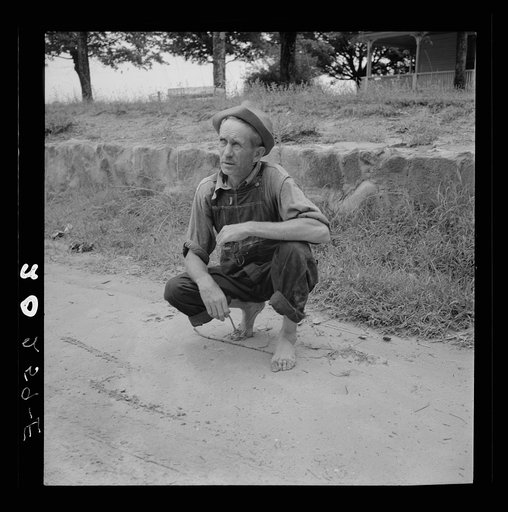 Roadside meeting with Durham County farmer. North Carolina. He gives road directions by drawing the dirt with a stick
