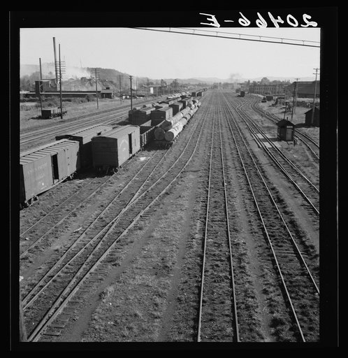 Untitled photo, possibly related to: Washington, Lewis County, Centralia. Railroad yard, looking down from highway bridge. Disaster to the town: the one remaining lumber mill burned down a week before. (Note smoke and wreckage)