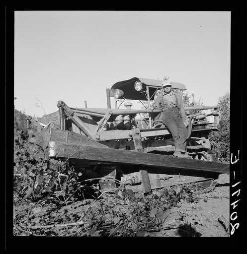 Untitled photo, possibly related to: Western Washington, Lewis County. Bulldozer raises and pushes stump on cut-over farm