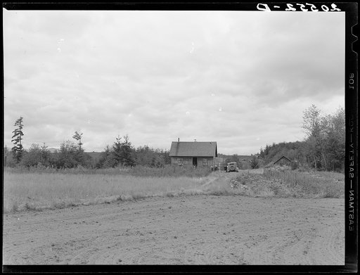 The Arnold farm, seen from road. Traveling medicine salesman is calling. Shows vegetable garden to right, and berry patch in front of house. The land which family has cleared is across a deep gully at the back and extends up and over the hill behind the house. Western Washington, Thurston County, Mi