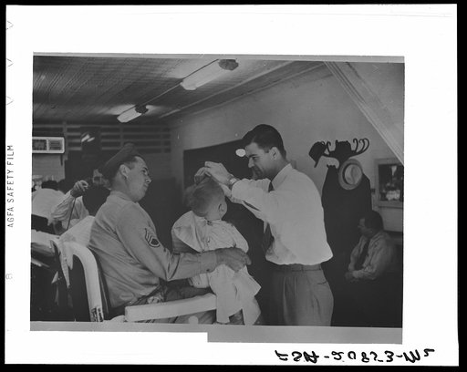 Sergeant from Fort Benning getting his son's hair cut at a barber shop in Columbus, Georgia