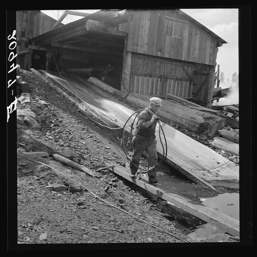 "Pond monkey" carrying cable from mill shed to pond. Keno, Klamath County, Oregon