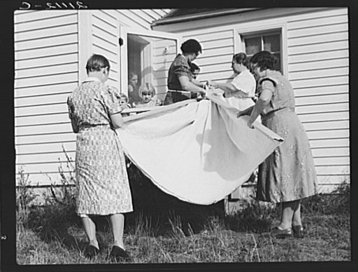 Untitled photo, possibly related to: Farm women, members of the "Helping Hand" club, carefully roll up the quilt upon which they are working. Near West Carlton, Yamhill County, Oregon. General caption number 58-11