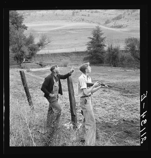Farmer and boy in the fall of the year at the time the hunting season opens. They live in a white painted house across the road. Jackson County, Oregon
