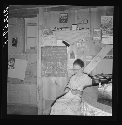 Untitled photo, possibly related to: Mrs. Hull in one-room dugout basement home (note blackboard.) "I wanted a blackboard for a long time for my Bible verses, to keep them in our mind. Got it last year." Dead Ox Flat, Malheur County, Oregon. General caption number 67-111