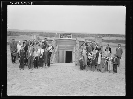 Friends church (Quaker), Dead Ox Flat, Malheur County, Oregon. The entire family after Sunday morning services. Preacher is a young farmer. Man at left holding baby. See general caption number 67-II