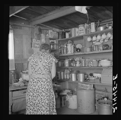 Woman getting lunch in kitchen of home. Homedale district, Malheur County, Oregon