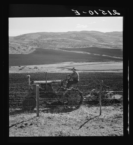 Untitled photo, possible realted to: Young Idaho farmer plowing in the fall of the year while the other members of the Ola self-help sawmill co-op are working in the sawmill. The tractor does work for five member families. Gem County, Idaho