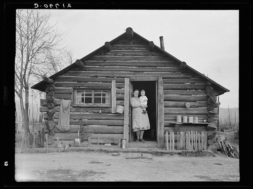 Log house now occupied and enlarged by the Halley family. Mrs. Halley in doorway with youngest child. Bonner County, Idaho. See general caption 51