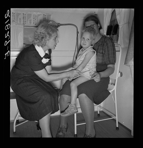 In trailer clinic. The nurse consults the migrant mother whose small boy is ailing. Merrill FSA (Farm Security Administration) camp, Klamath County, Oregon. See general caption 62