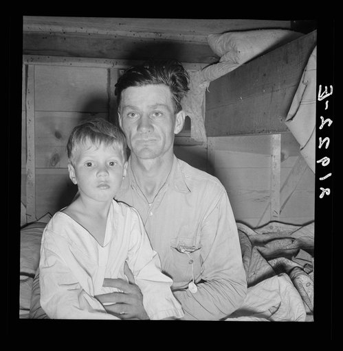 He brought his family to the west in a homemade trailer from Texas five months ago. Photograph made after supper. Boy sick. Father has work now in potato field. Merrill, Klamath County, Oregon. In mobile unit, FSA (Farm Security Administration) camp