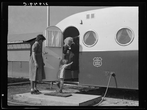 Young mother brings her child to the trailer clinic on the day when the doctor will be in camp to examine some of the children. Merrill, Klamath county, Oregon. FSA (Farm Security Administration) camp