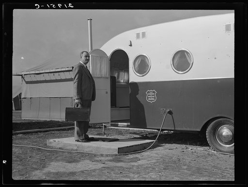 The doctor arrives in camp, by previous appointment with the nurse. Seen entering the mobile trailer clinic. Merrill, Klamath County, Oregon, FSA (Farm Security Administration) camp