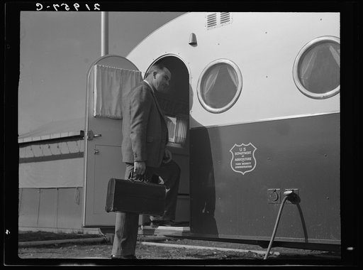 The doctor arrives in camp by previous appointment with the nurse. Seen entering the mobile trailer clinic at FSA (Farm Security Administration) mobile camp. Merrill, Klamath County, Oregon