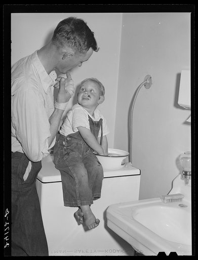 Father watching son being treated at health clinic. Tulare migrant camp  Visalia, California